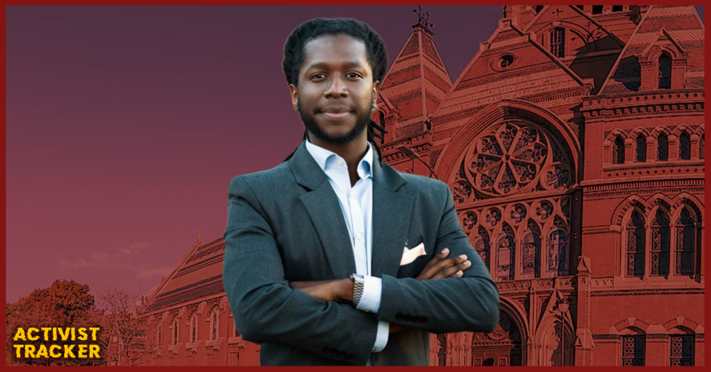 Image of Elom Tettey-Tamaklo, Harvard Divinity School graduate recently hired by Harvard University despite prior assault charges during a 2023 protest, standing confidently in front of Memorial Hall. Used in Activist Tracker coverage of Harvard’s role in escalating campus antisemitism and university extremism.